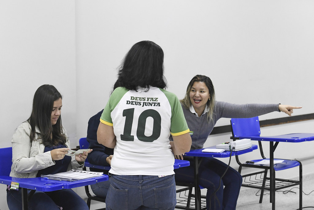 Eleitora recebe orientação dos mesários na seção eleitoral