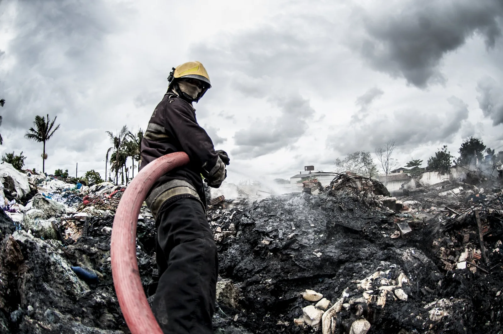 Bombeiro com mangueira em área atingida por incêndio em Navegantes, Santa Catarina