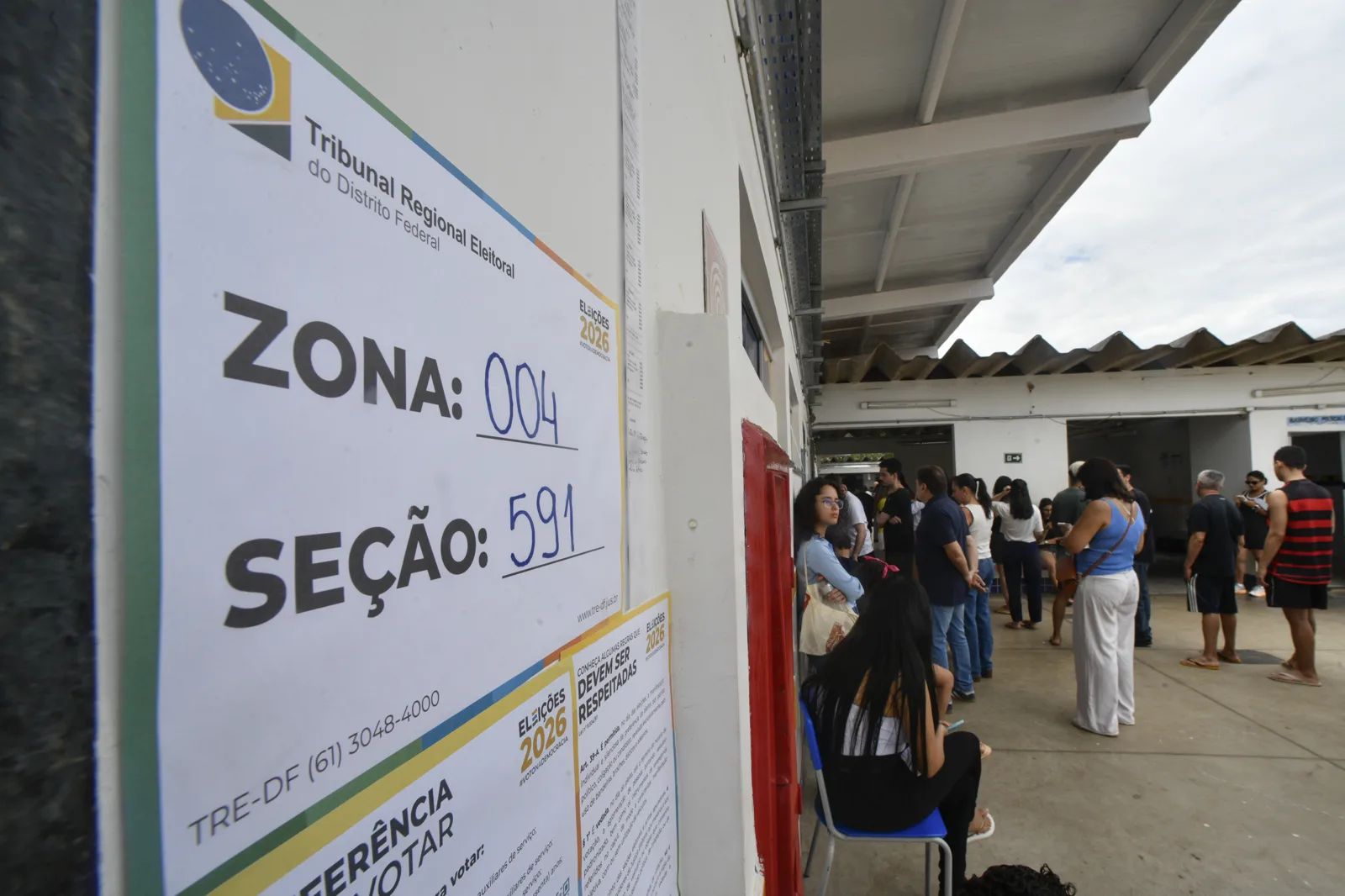 Mesário auxilia eleitor durante votação do primeiro turno de 2026